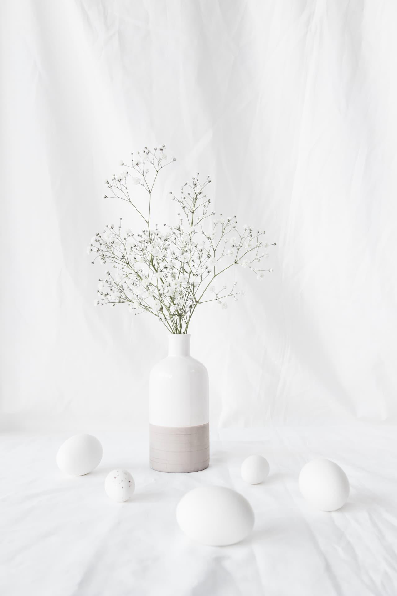 Arranjo delicado em vaso branco sobre mesa, ambiente clean e acolhedor da Bioclin
