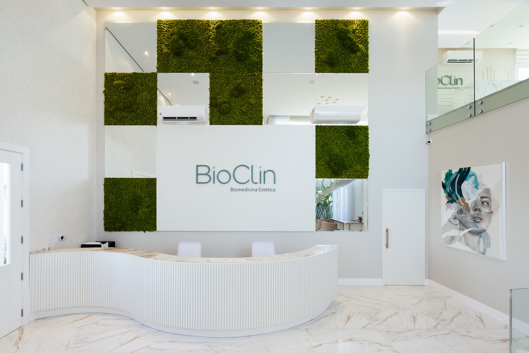 Recepção da Bioclin com parede viva e balcão curvo em mármore